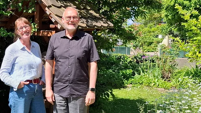 3 Pfarrer/Innen stehen im Pfarrgarten