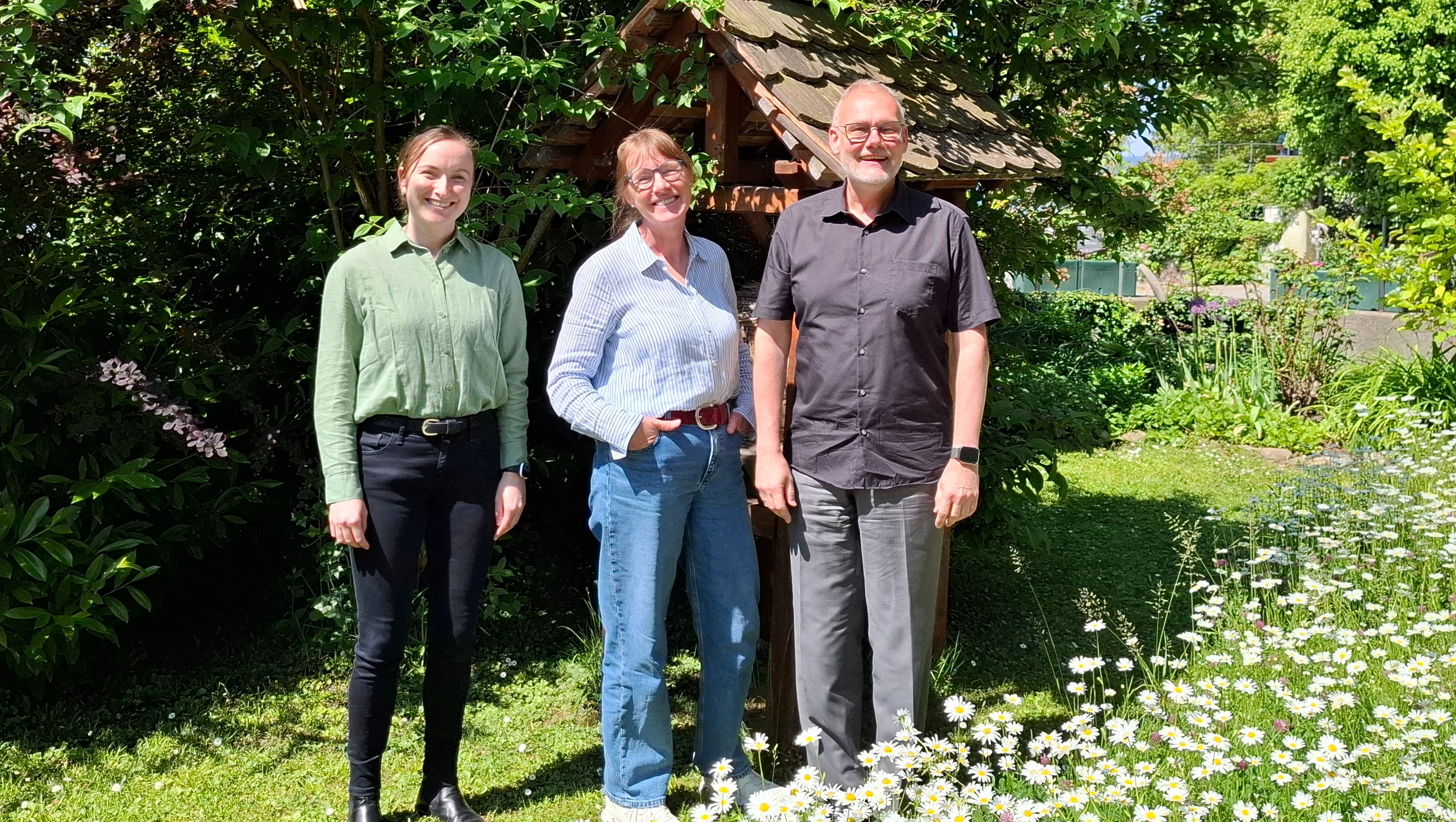 3 Pfarrer/Innen stehen im Pfarrgarten